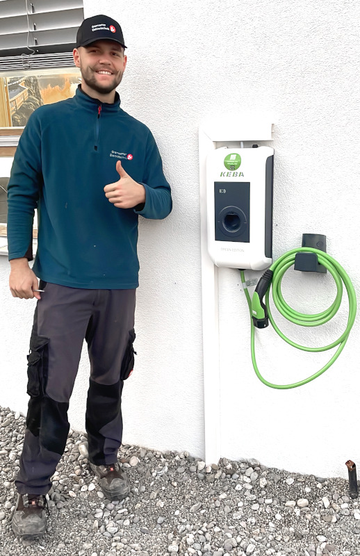 Mitarbeiter von Gramsamer Elektrotechnik neben einer Wallbox
